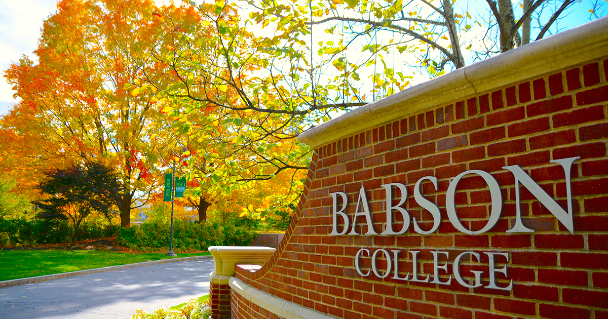 巴布森学院大门的特写镜头，背景beplay平台下载是秋天的树叶